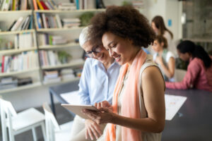 Image of two smiling women accessing a tablet computer