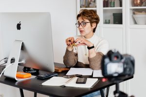 Female watching Apple computer screen at desk